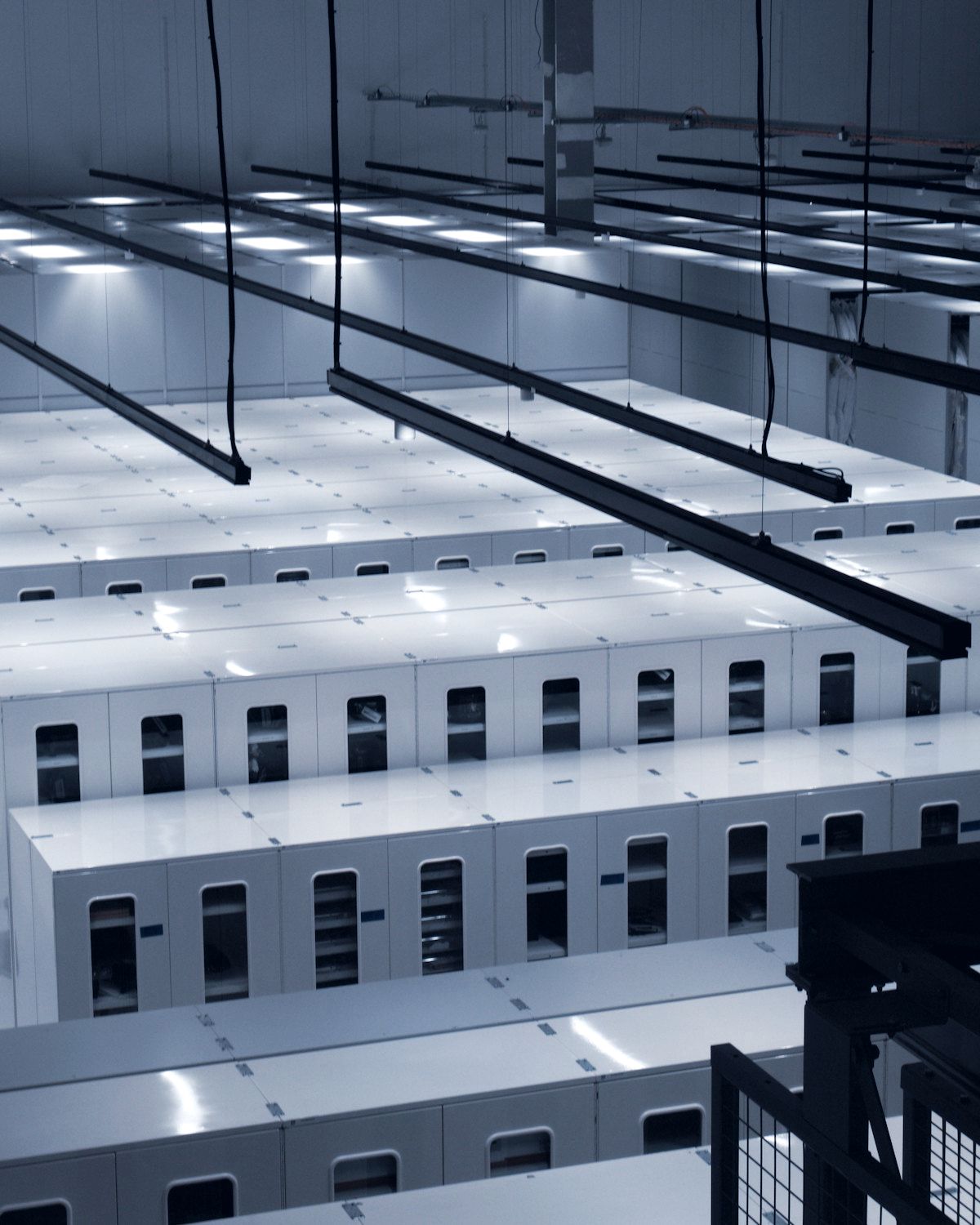 Rows of white server cabinets in a modern data center.